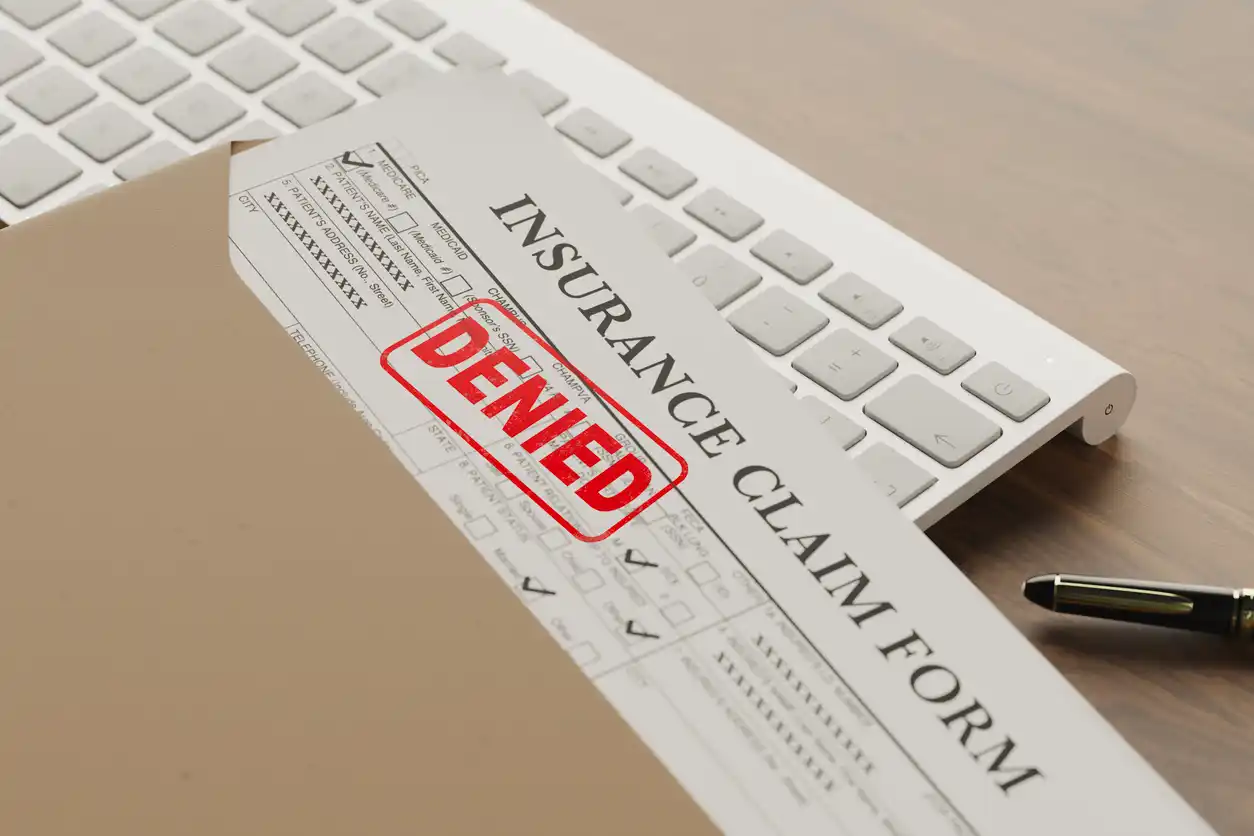 Denied health insurance application form on the table.